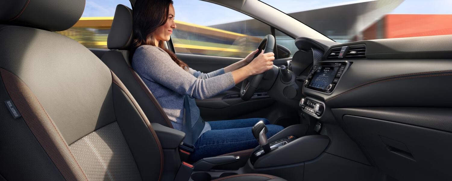 Femme au volant de la Nissan Versa 2025.